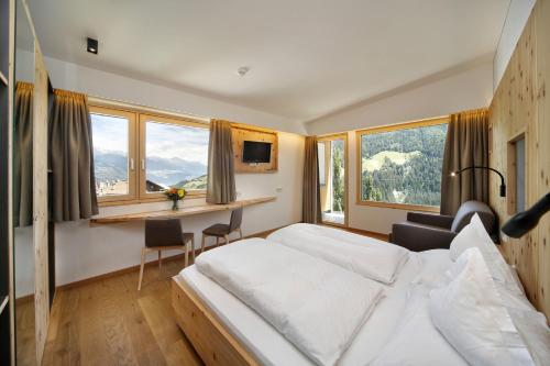 斯泰尔维奥Hotel Sonne的酒店客房设有一张床、一张书桌和窗户。
