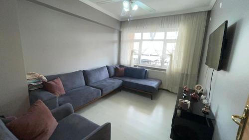 YenimahalleKonuk evi的客厅设有蓝色的沙发和窗户。