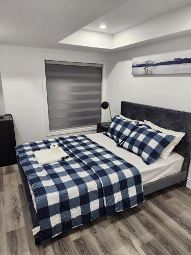 InnisfilNew Modern room in Innisfil的卧室配有蓝色和白色的格子床