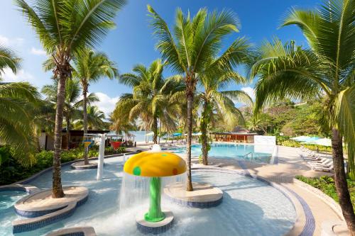 维拉港瓦努阿图假日酒店度假村的一个带棕榈树水上公园的游泳池