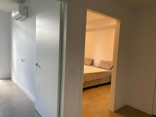 布莱克敦The Cozy Retreat, 1 Oxford St, Blacktown , NSW的一间设有床铺的房间和通往卧室的门
