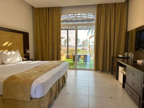 塞拉莱Samharam Resort Salalah的酒店客房设有一张床和一个大窗户