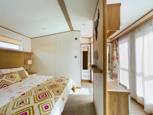 塔特舍尔Tattershall Lakes Mini Breaks - Osprey Rise的一间卧室设有一张床和一个大窗户