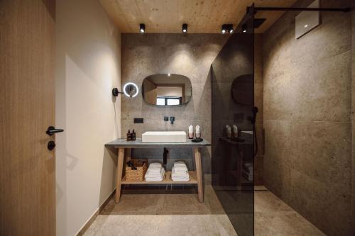 莱奥冈Boutique Hotel Das Rivus的一间带水槽和镜子的浴室