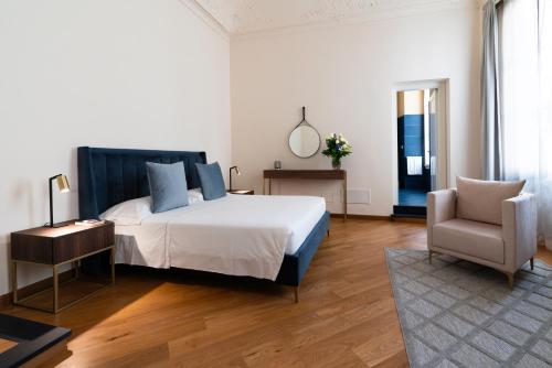 热那亚The Seven Residence的一间卧室配有一张大床和一把椅子