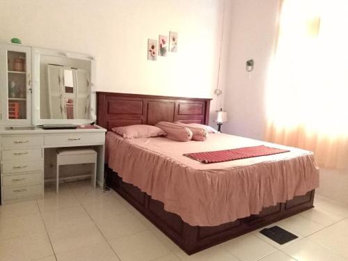 WahaWambuliga Homestay的一间卧室配有一张带梳妆台和镜子的床