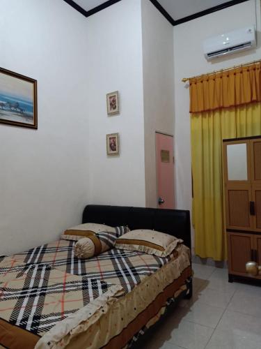 WahaWambuliga Homestay的一间卧室配有床和黄色窗帘