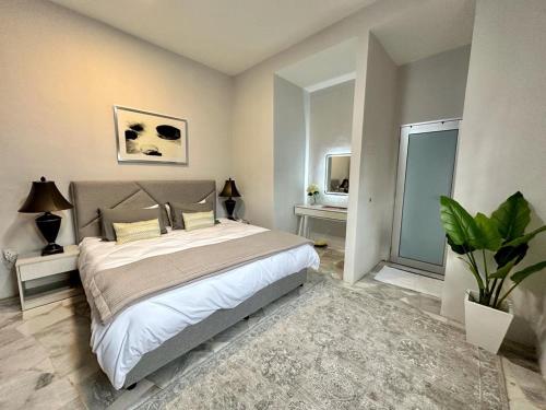 Tanjong SepatThe P Lakehouse的一间卧室配有一张大床和盆栽植物