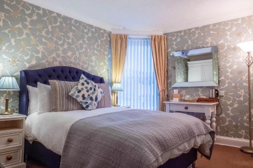 凯西克桑尼塞得旅馆的一间卧室配有蓝色的床和镜子
