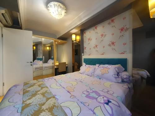 雅加达Apartemen Gading Icon的一间卧室配有一张带紫色棉被的床