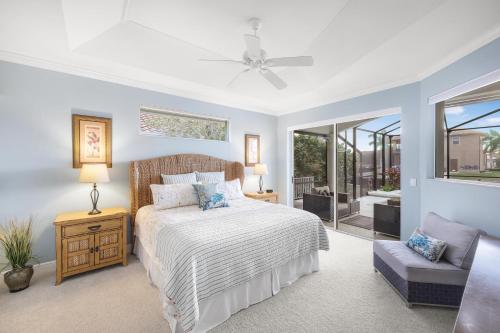 马可岛396 Bald Eagle Drive的一间卧室配有一张床、一把椅子和窗户。