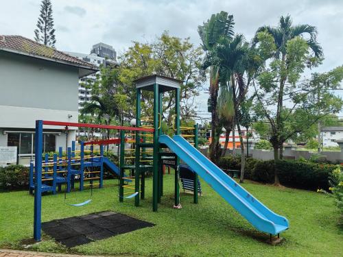 马六甲Klebang GX Homestay Resort Pool View P0804 with Netflix, TVBox and Games的庭院里一个带蓝色滑梯的游乐场