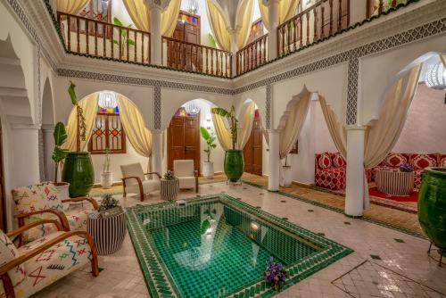 马拉喀什Riad Ekla Boutique Hotel的客厅,在房间中间设有游泳池