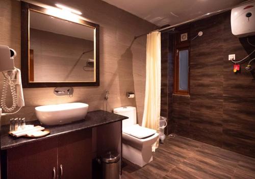 佩林Kaya Gantavya Resort的一间带水槽、卫生间和镜子的浴室