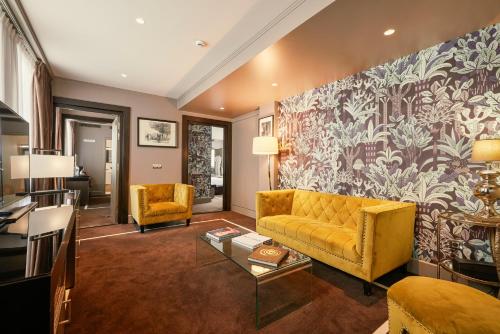 巴黎Juliana Hotel Paris的客厅设有黄色沙发和壁画