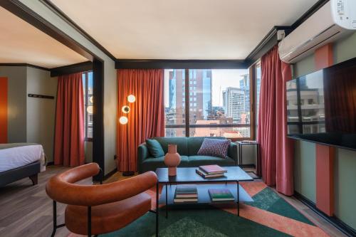圣地亚哥APT Serviced Apartments Santiago的酒店客房配有床、沙发和桌子。
