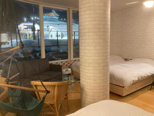 白马村Lift Inn Hakuba Goryu的带沙发、床和窗户的客厅