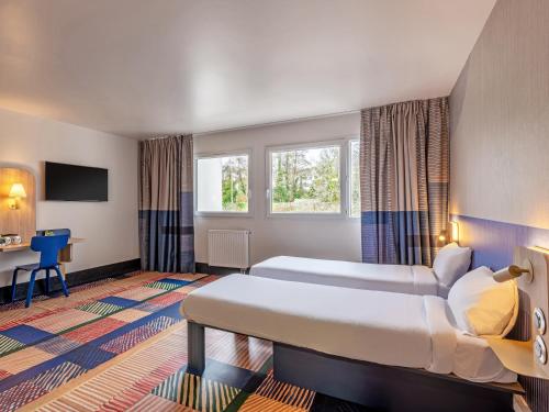 布雷斯特B&B HOTEL Brest Port du Moulin Blanc的酒店客房配有两张床和一张书桌