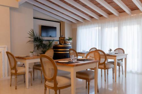 明乔河畔的瓦雷奇奥Relais Ca' Morenica的一间带桌椅和电视的用餐室