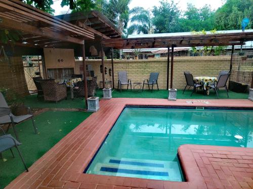 纳布姆斯普雷特Africas Eden Guesthouse的庭院内的游泳池,配有桌椅