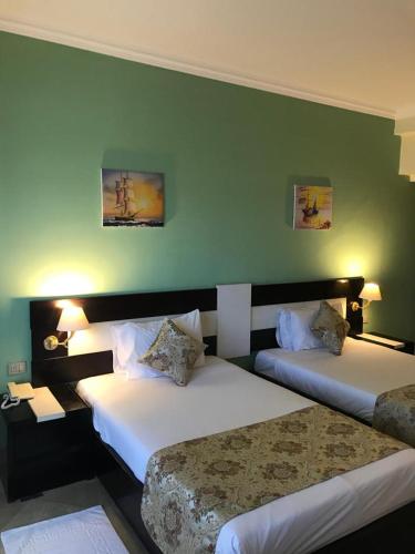 赫尔格达Moreno Resort and Spa的酒店客房设有两张床和绿色的墙壁。