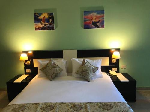 赫尔格达Moreno Resort and Spa的一间卧室配有一张带两盏灯的大型白色床。