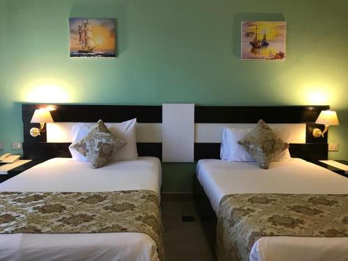 赫尔格达Moreno Resort and Spa的酒店客房,设有两张床和两张墙上的照片