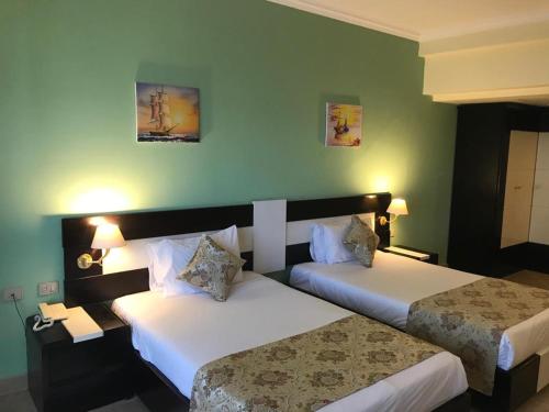赫尔格达Moreno Resort and Spa的绿墙旅馆客房的两张床