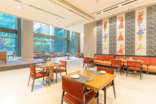 海得拉巴海得拉巴万怡酒店 的餐厅设有桌椅和窗户。