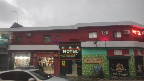 圣保罗Hotel Ferrari的街上的一座红色建筑,与酒店同在