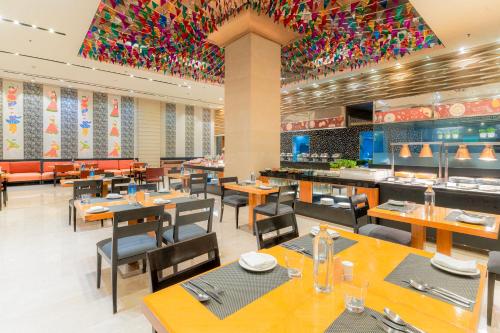 海得拉巴海得拉巴万怡酒店 的一间带桌椅的用餐室和一间餐厅
