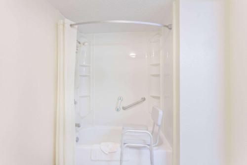 诺克斯维尔西诺克斯维尔速8酒店的白色浴室设有白色浴缸和白色椅子