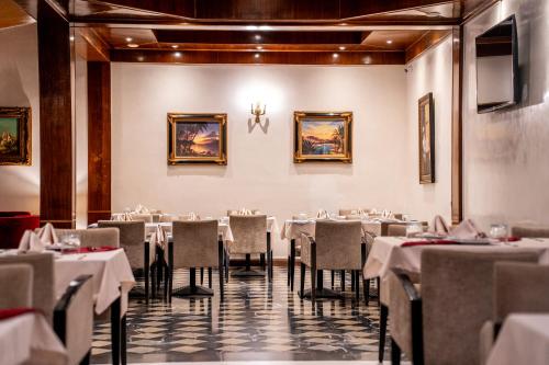 拉巴特Hôtel L'Hacienda的一间设有白色桌椅的用餐室