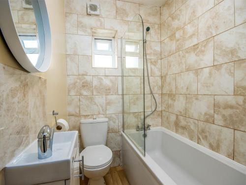 南安普敦4 Bed House With Driveway Parking的浴室配有卫生间、浴缸和水槽。
