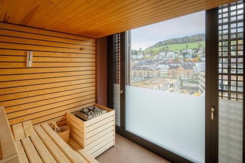 圣加仑Tailormade Hotel LEO St Gallen的客房设有带大窗户的桑拿浴室。