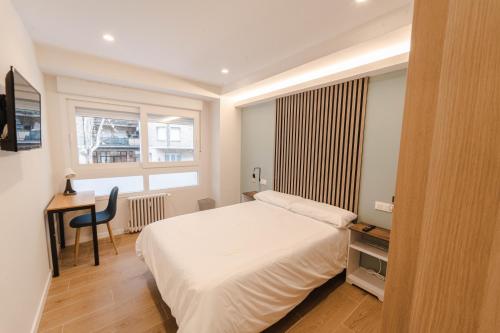 马德里I'M Room Suites Nuevos Ministerios - Bernabeu 'Digital Access'的一间卧室配有一张床、一张书桌和一个窗户。
