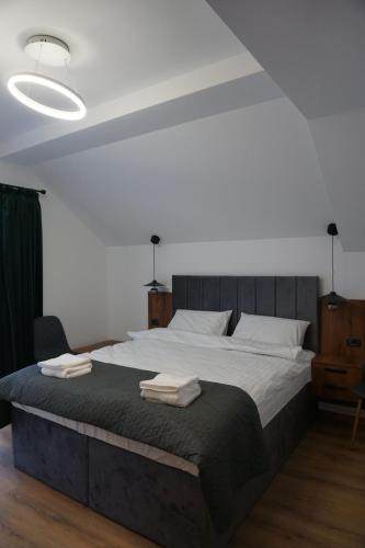 博尔沙Pensiunea Cascada的一间卧室配有一张大床和毛巾