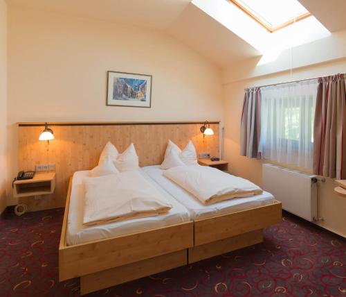 基姆湖畔普林Hotel Luitpold am See的卧室配有带白色枕头的大床