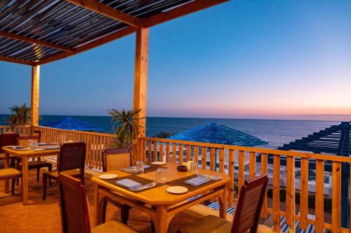 沙姆沙伊赫大绿洲度假酒店的一个带桌椅的甲板和大海