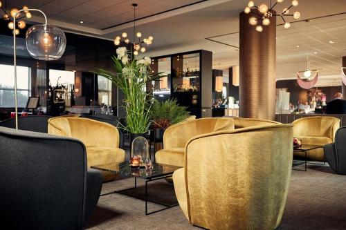 迭戈姆布鲁塞尔机场范德瓦尔克酒店的大堂设有桌椅和酒吧
