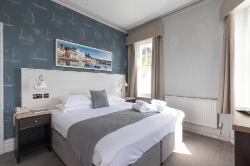 圣莫斯船堡酒店的一间卧室设有一张大床和蓝色的墙壁