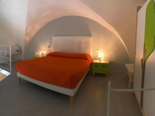 焦维纳佐Porto di mare luxury home的一间白色客房内的卧室,配有一张橙色的床
