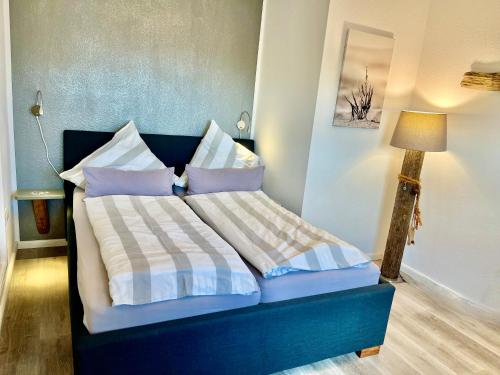 韦斯特雷费尔Hof Steinhütten的一间卧室配有蓝色的床、枕头和灯