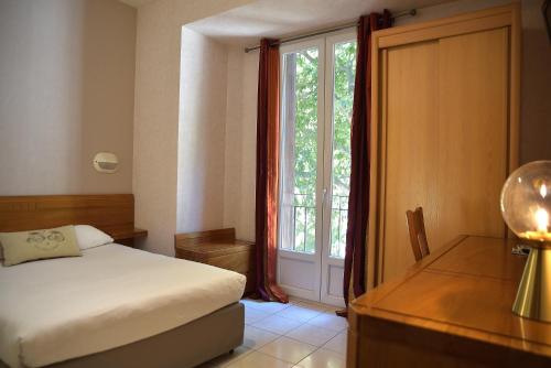 巴斯蒂亚波拿巴特酒店的一间卧室配有一张床、一张书桌和一个窗户。