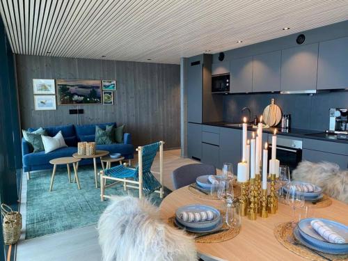 亨宁斯韦尔Waterfront apartment with panoramic sea view的厨房以及带桌子和沙发的用餐室。