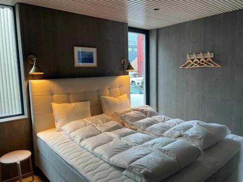 亨宁斯韦尔Waterfront apartment with panoramic sea view的一张带白色枕头的大床