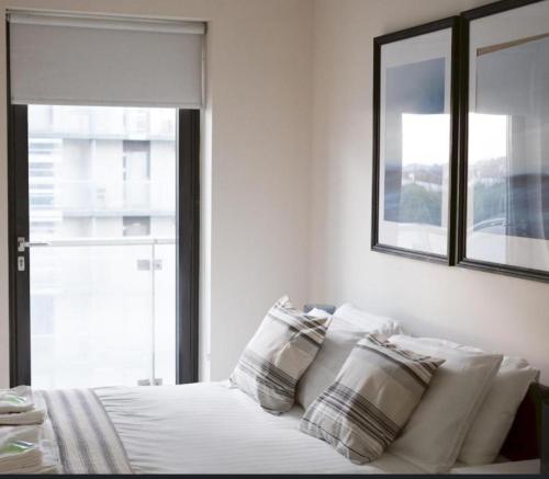 格拉斯哥Water view harbour的卧室配有带枕头的床铺和窗户。