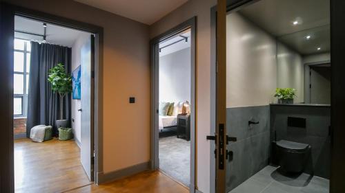 曼彻斯特Manhattan by The Heim Residences的走廊上设有通往浴室的门