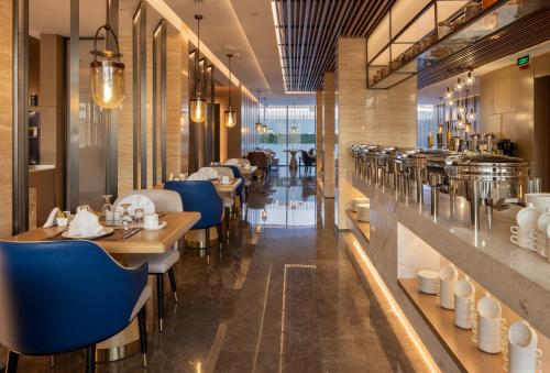 布赖代Boudl Al Rawdah的一间在房间内配有蓝色椅子和桌子的餐厅
