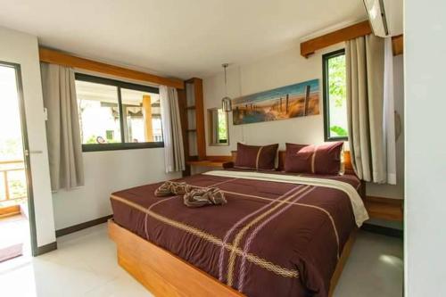 班邦宝BangPo Resort的一间卧室配有一张大床,上面有两双鞋